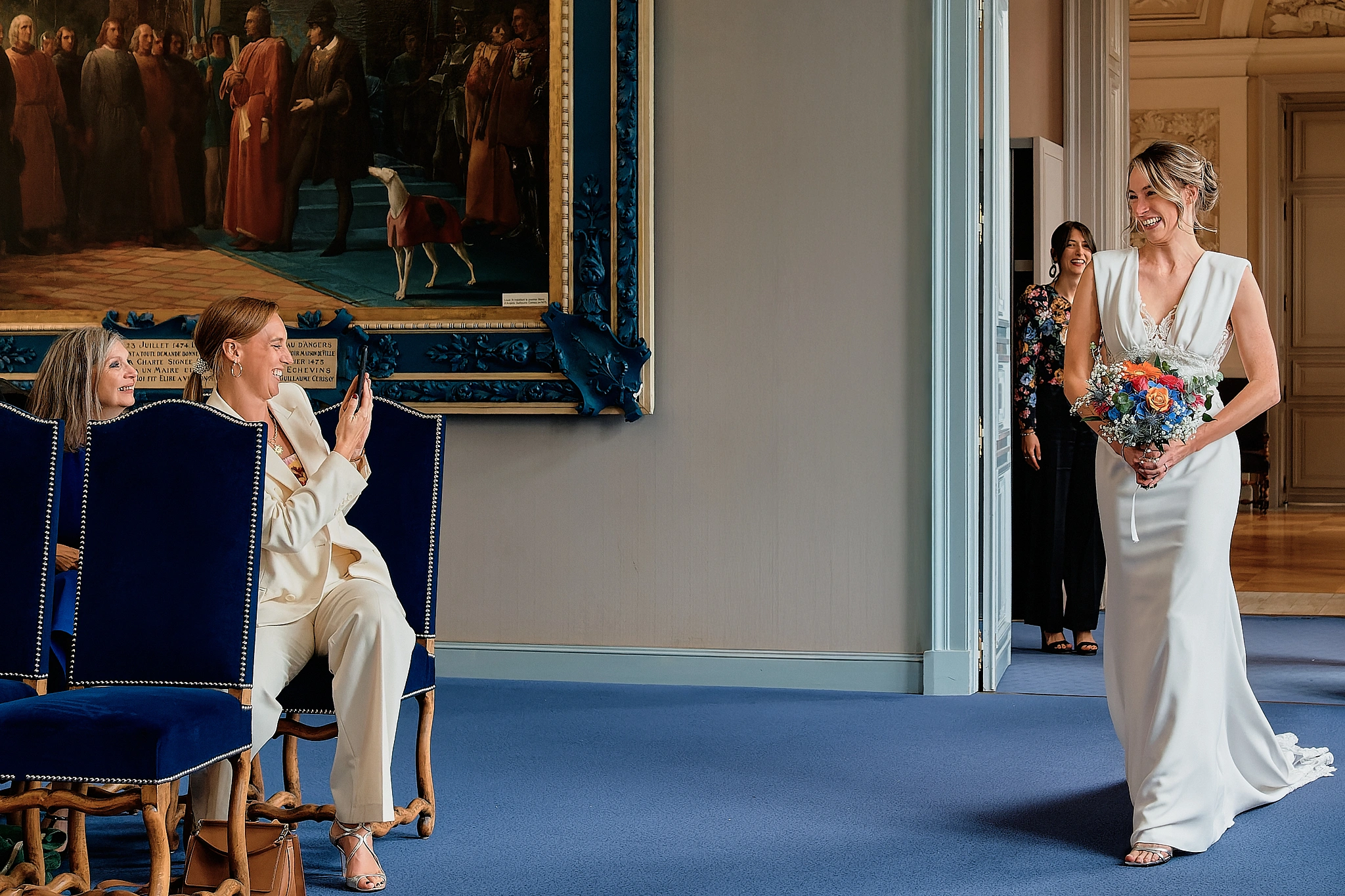 la photo de mariage montre la mariée jetant un regard complice à ses proches lors de son entrée de mariée mariage civil par nathalie marteau photographe mariage angers nantes rennes