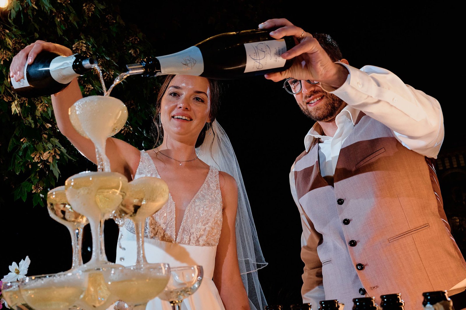 Audrey et Nicolas versent le champagne sur la pyramide de coupes, dans la cour du château du Plessis-Macé