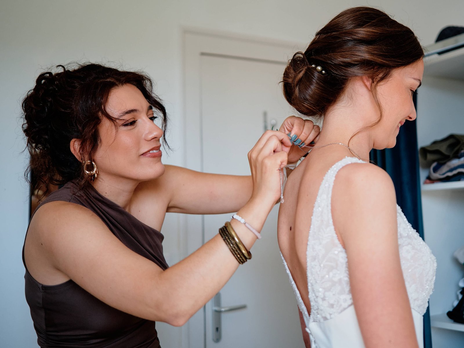 Une amie ferme les boutons dans le dos de la robe d'Audrey, chignon orné des épingles de sa grand-mère